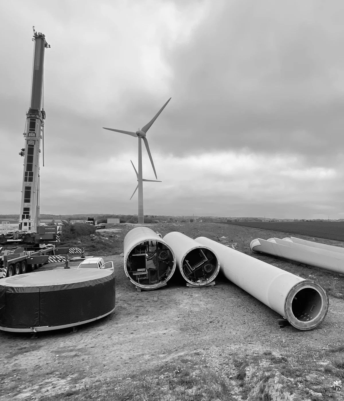 Dismantled wind turbine tower sections and blades at a European decommissioning site